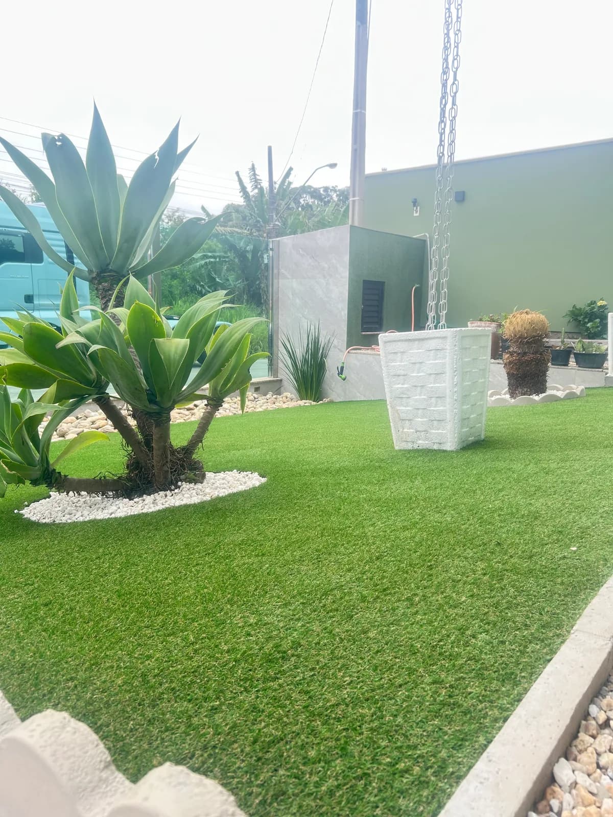 Jardim residencial com grama sintética — detalhe da instalação, Brusque SC