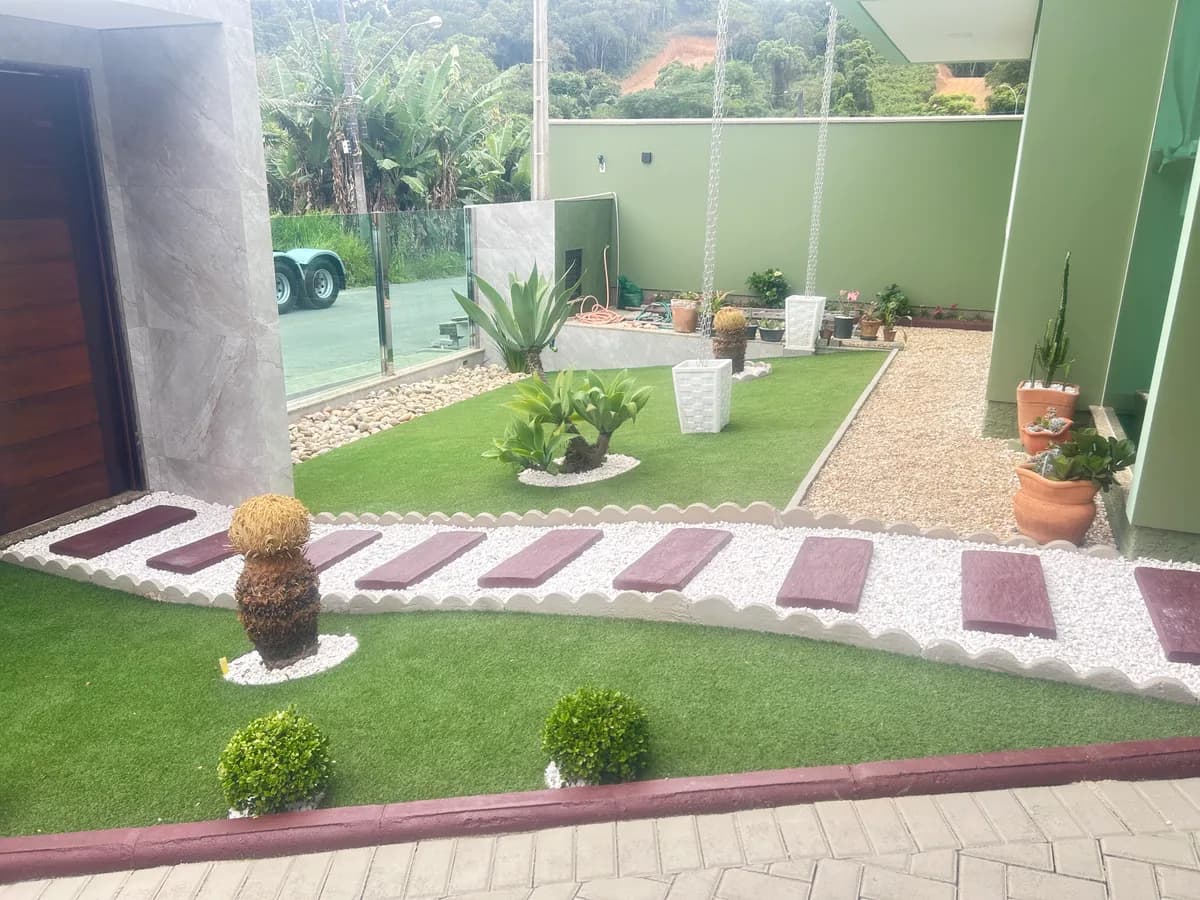 Jardim residencial após instalação de grama sintética pela Decor Gramas em Brusque